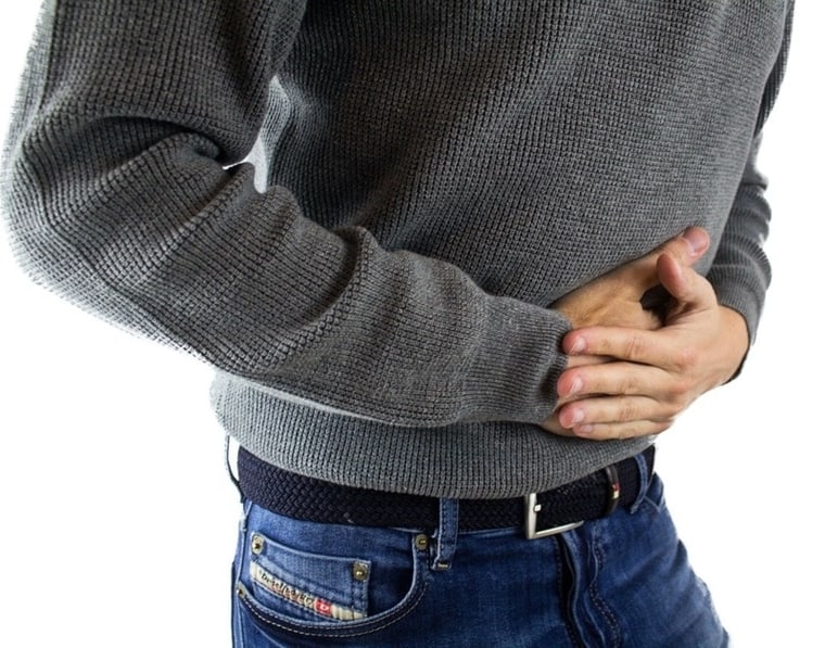 A man suffering from abdominal pain can be a colon cancer symptom often missed